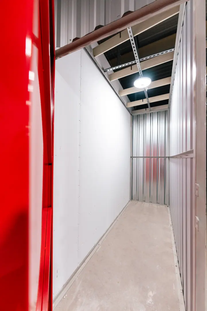 Wnętrze małego boksu magazynowego w Celtic Self Storage Łomianki — czerwone drzwi i oświetlenie