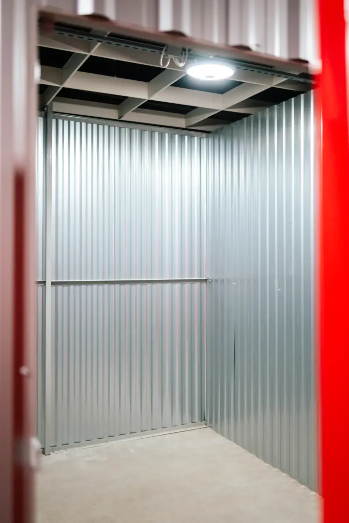 Czerwone drzwi boksów magazynowych z kłódkami — widok na korytarz Celtic Self Storage
