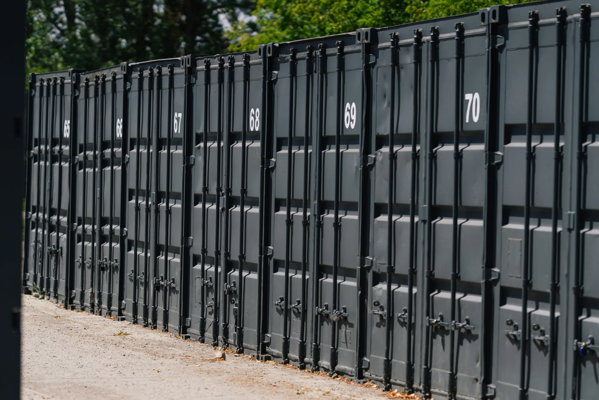 Rząd ponumerowanych kontenerów magazynowych na terenie Celtic Self Storage Piaseczno